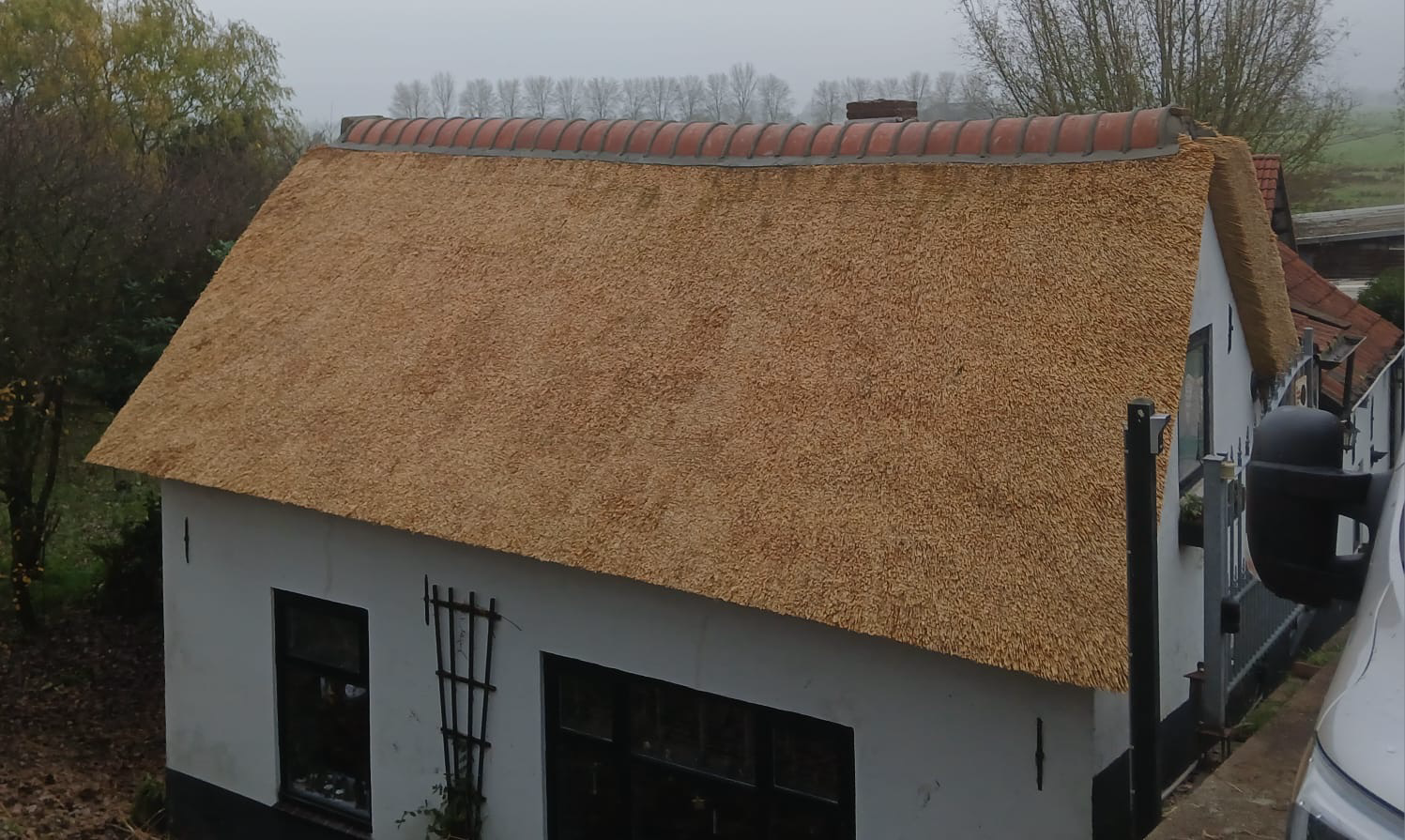 Woning met rieten dak en pannennok