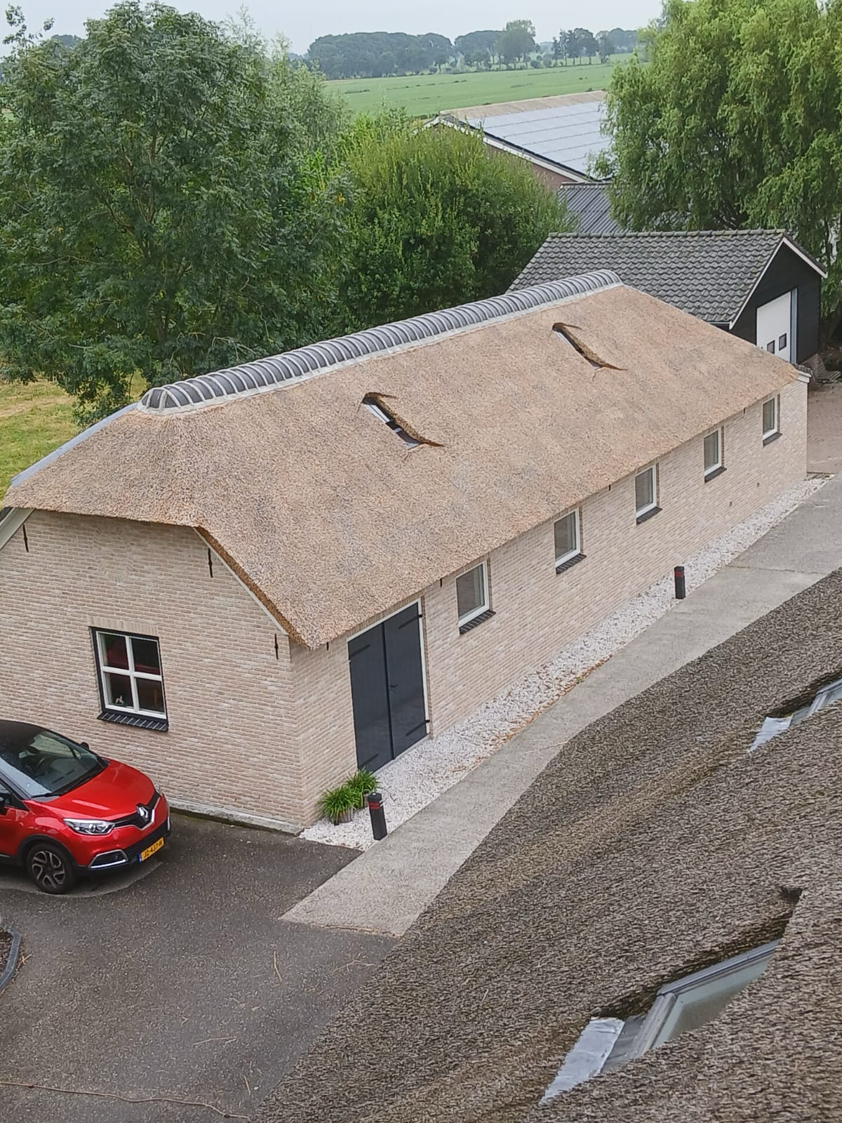 Lang bijgebouw met rieten dak